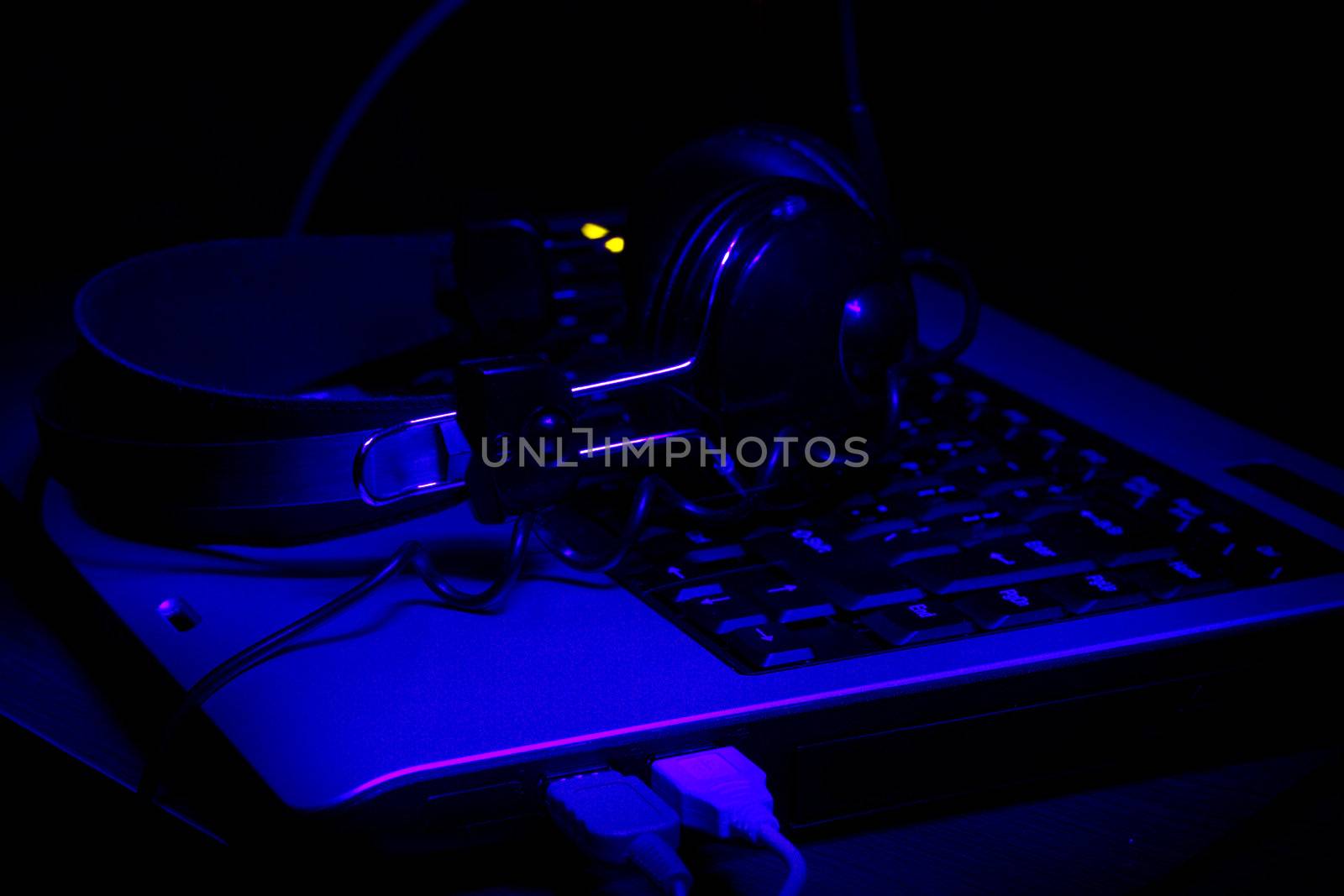 notebook keyboard and headphones in ultra-violet rays