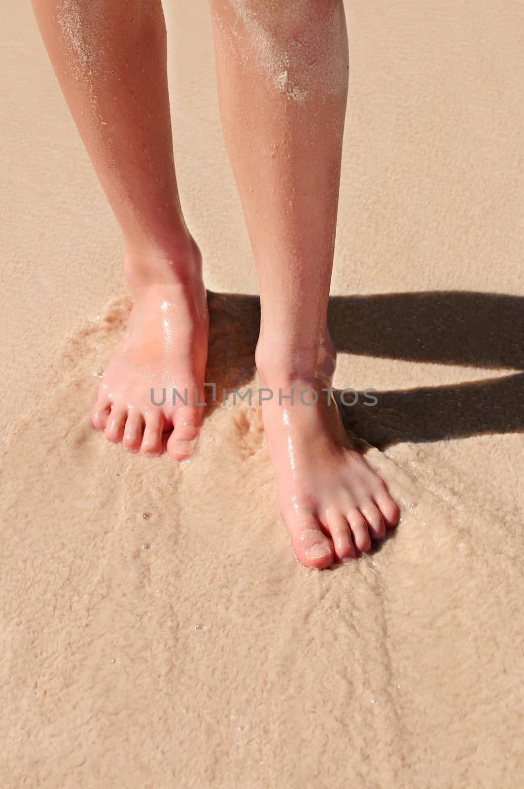Young woman's feet on a sandy beach