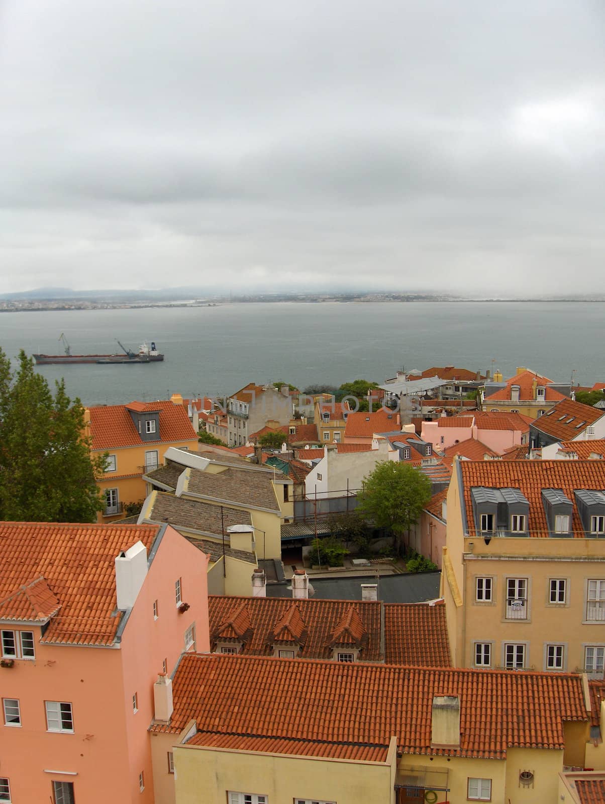 Colourful pastel homes with terra cotta tile rooves in Lisbon, Portugal