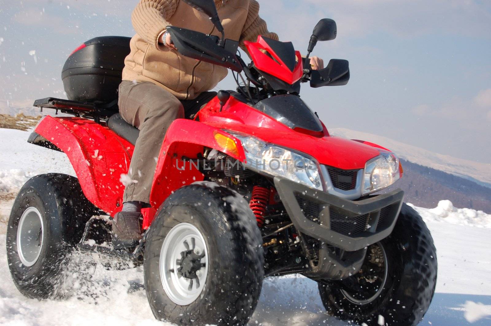 Man riding quad in mountain snow