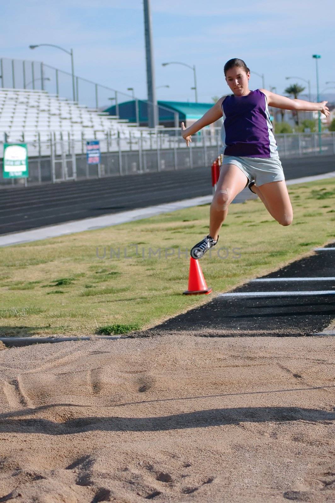 Teenage girl practicing long jump              