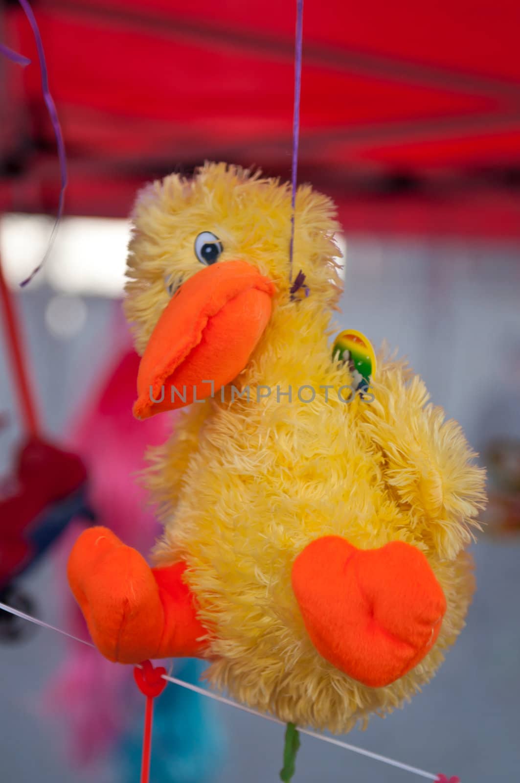 Children's toy yellow chicken hanging on a rope. High resolution image.