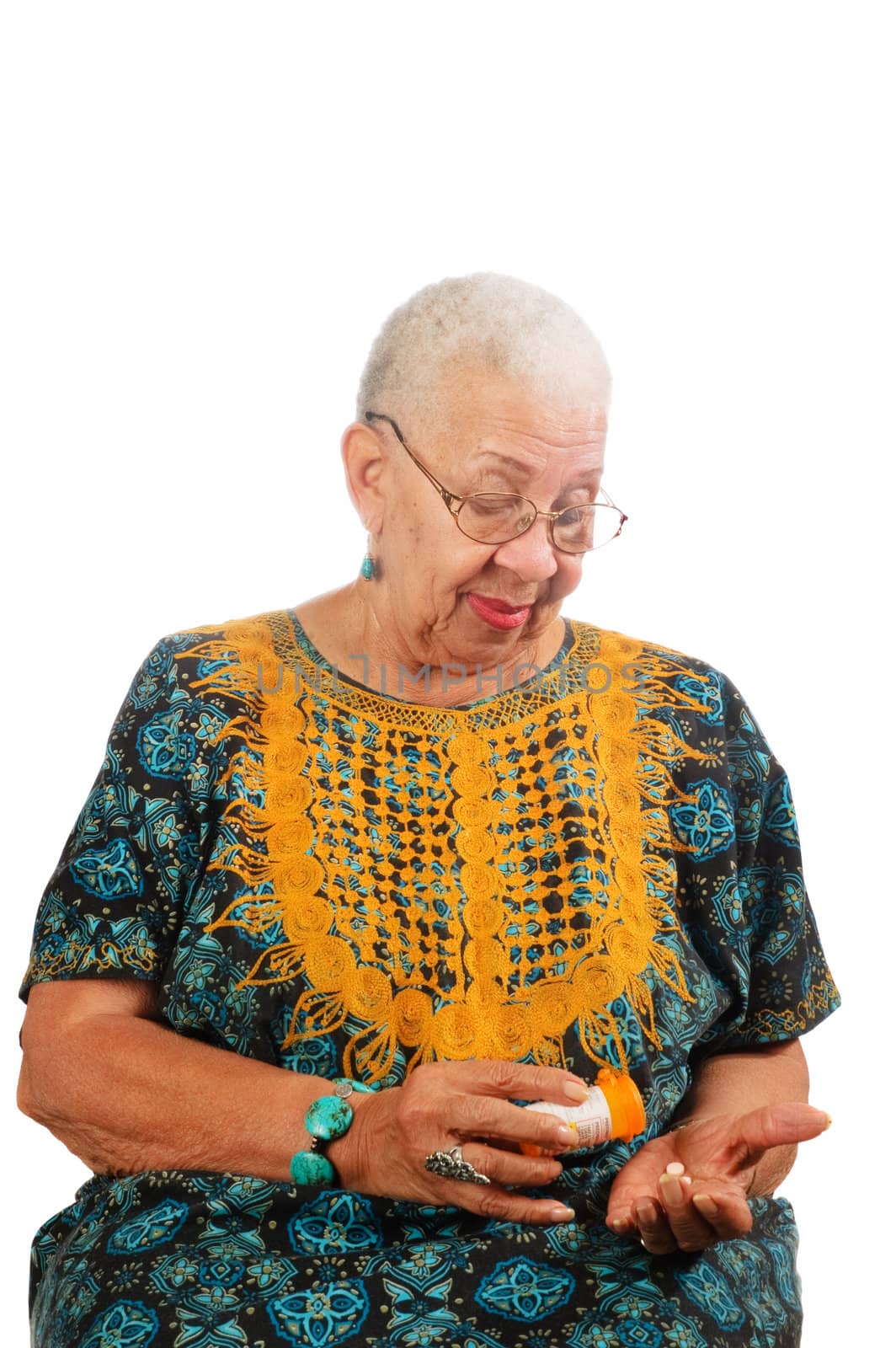 Elderly African American woman pouring her pills from a container into her hand