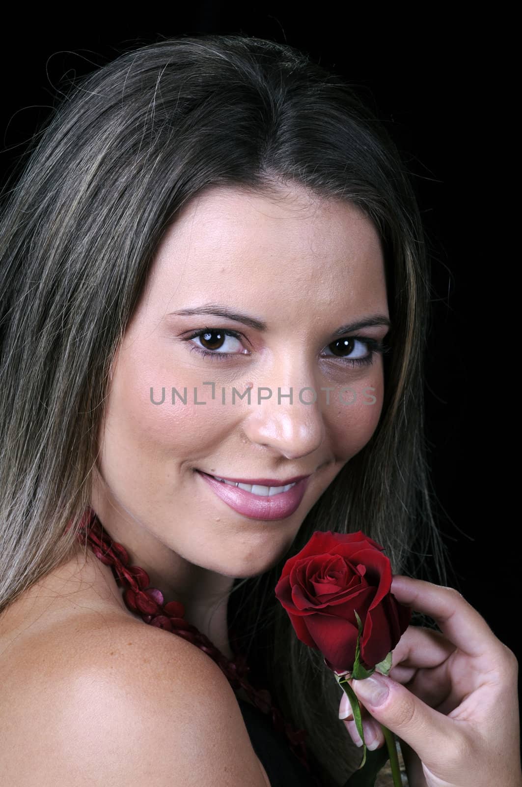 Beautiful young brunette woman holding a red rose a sign of love for valentines or any other special occasion