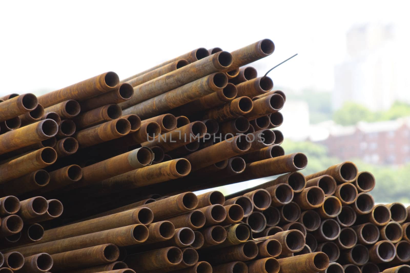 Warehouse of metal pipes. Rusty pipes lay on the earth.