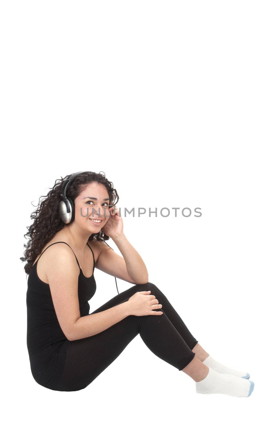 cute hispanic girl in a black leotard, smiling while listening to music on headphones