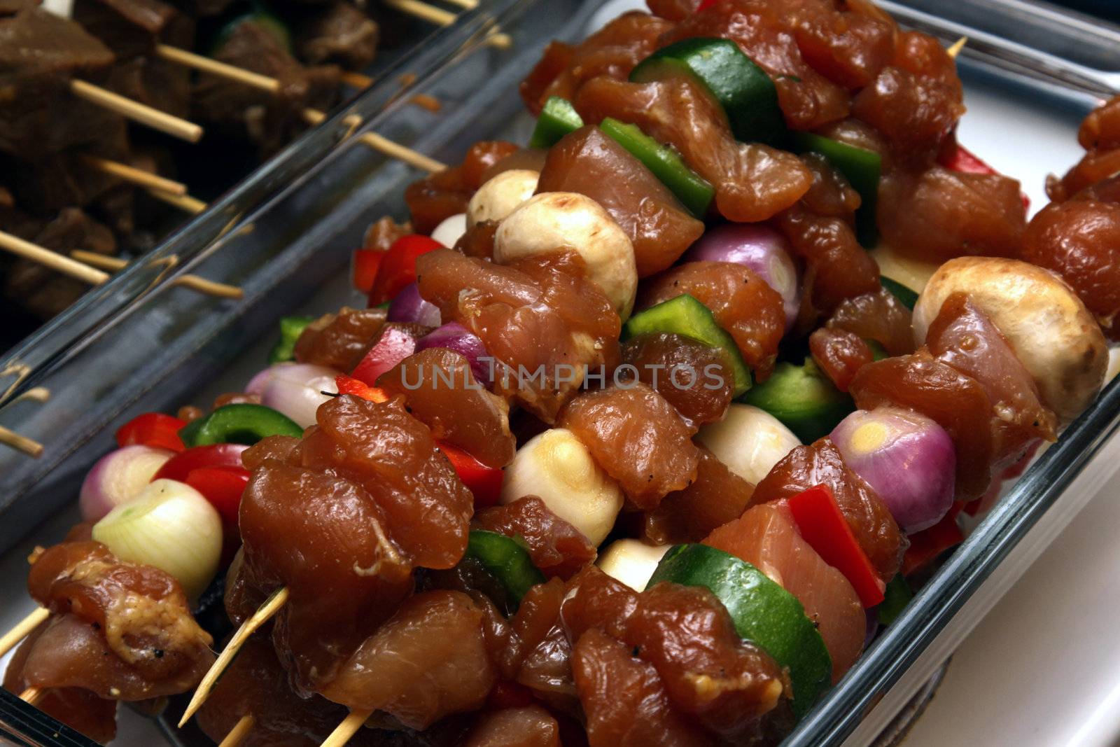 Chicken kebabs sitting ready to go on the barbeque.