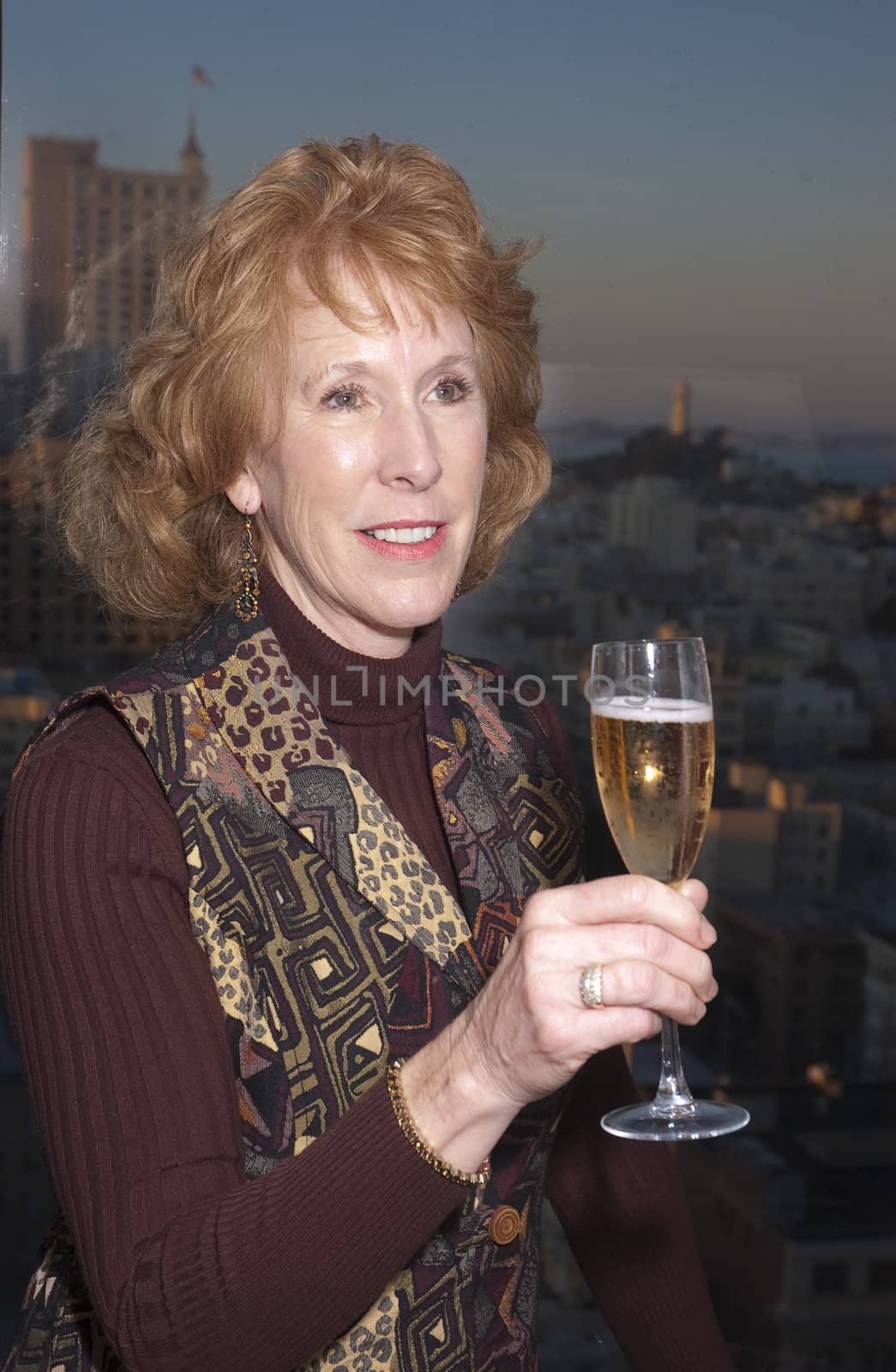 Woman celebrating with champagne in San Francisco Hotel with Coit tower in the background