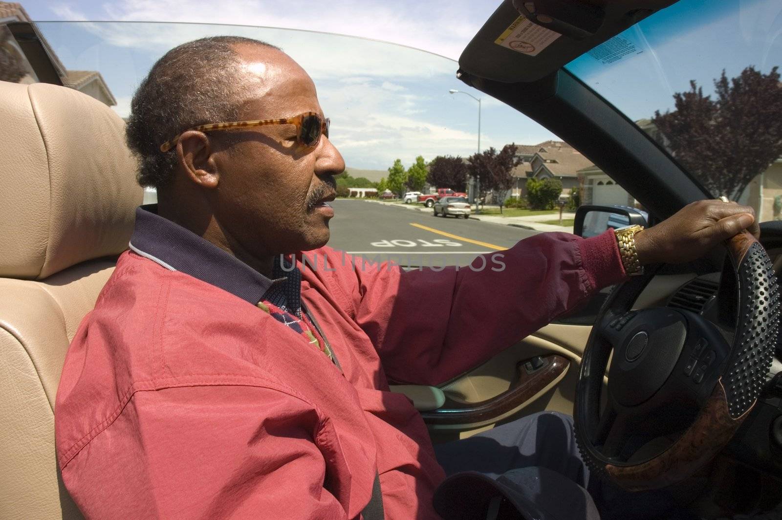 handsome Elderly African American man driving his car