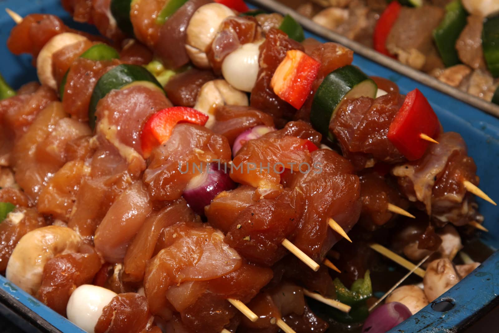 Chicken kebabs sitting ready to go on the barbeque.
