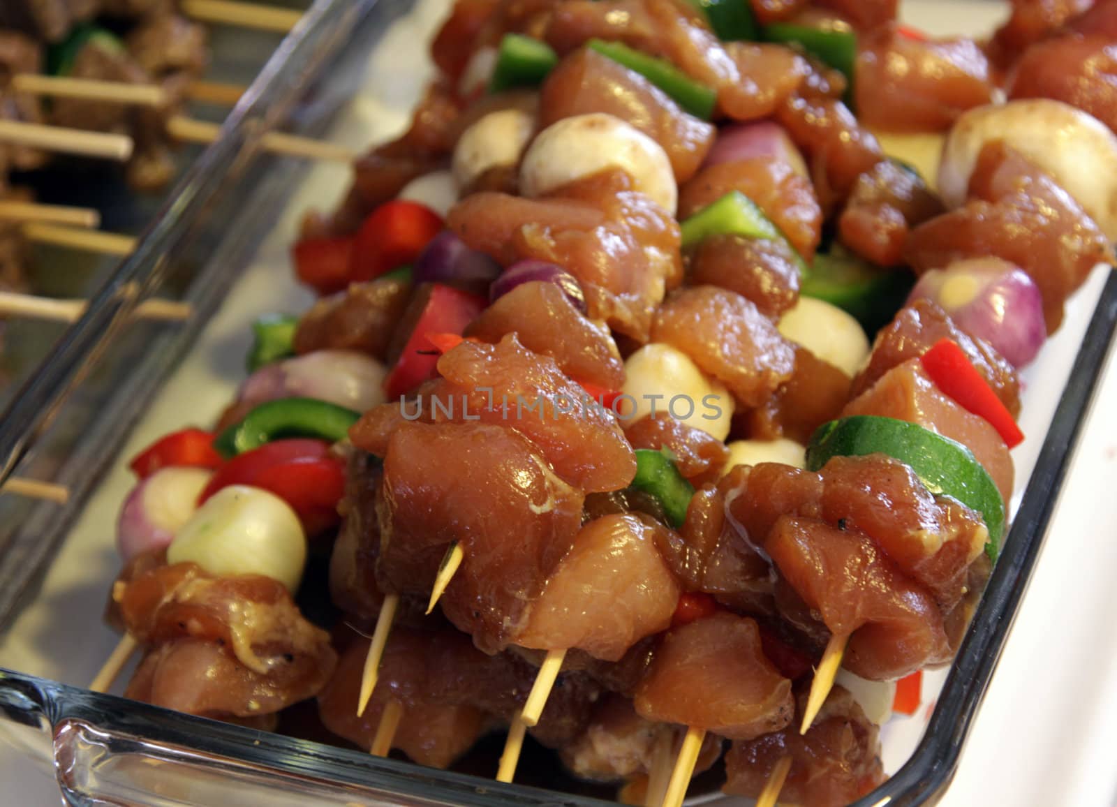 Chicken kebabs sitting ready to go on the barbeque.
