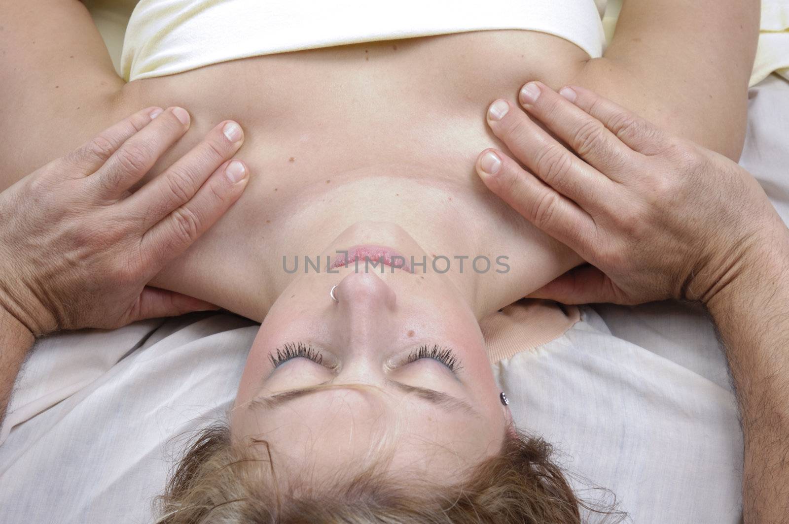 Woman having deep tisue shoulder massage from a masseur