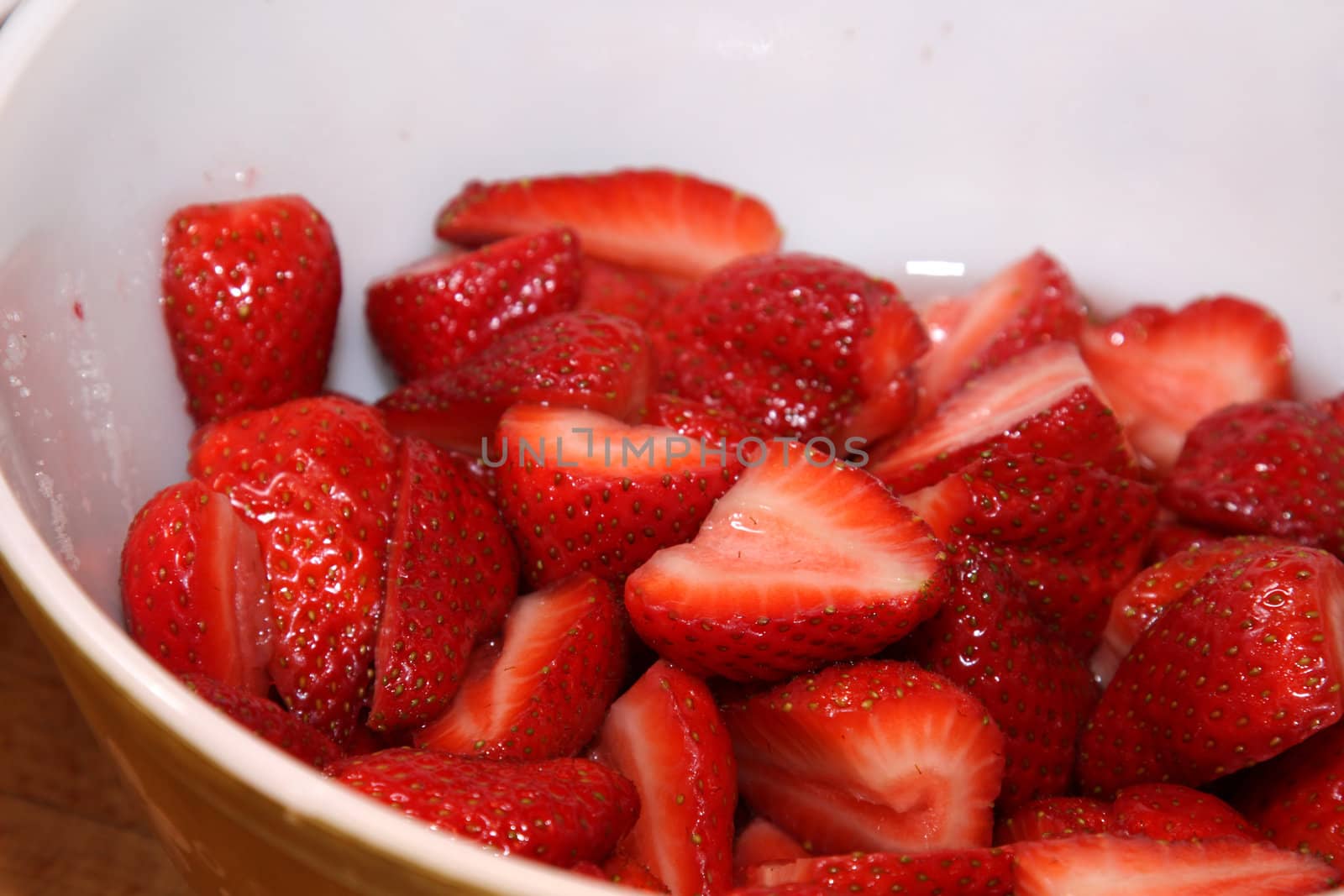 A bowl of freshly cut strawberries.
