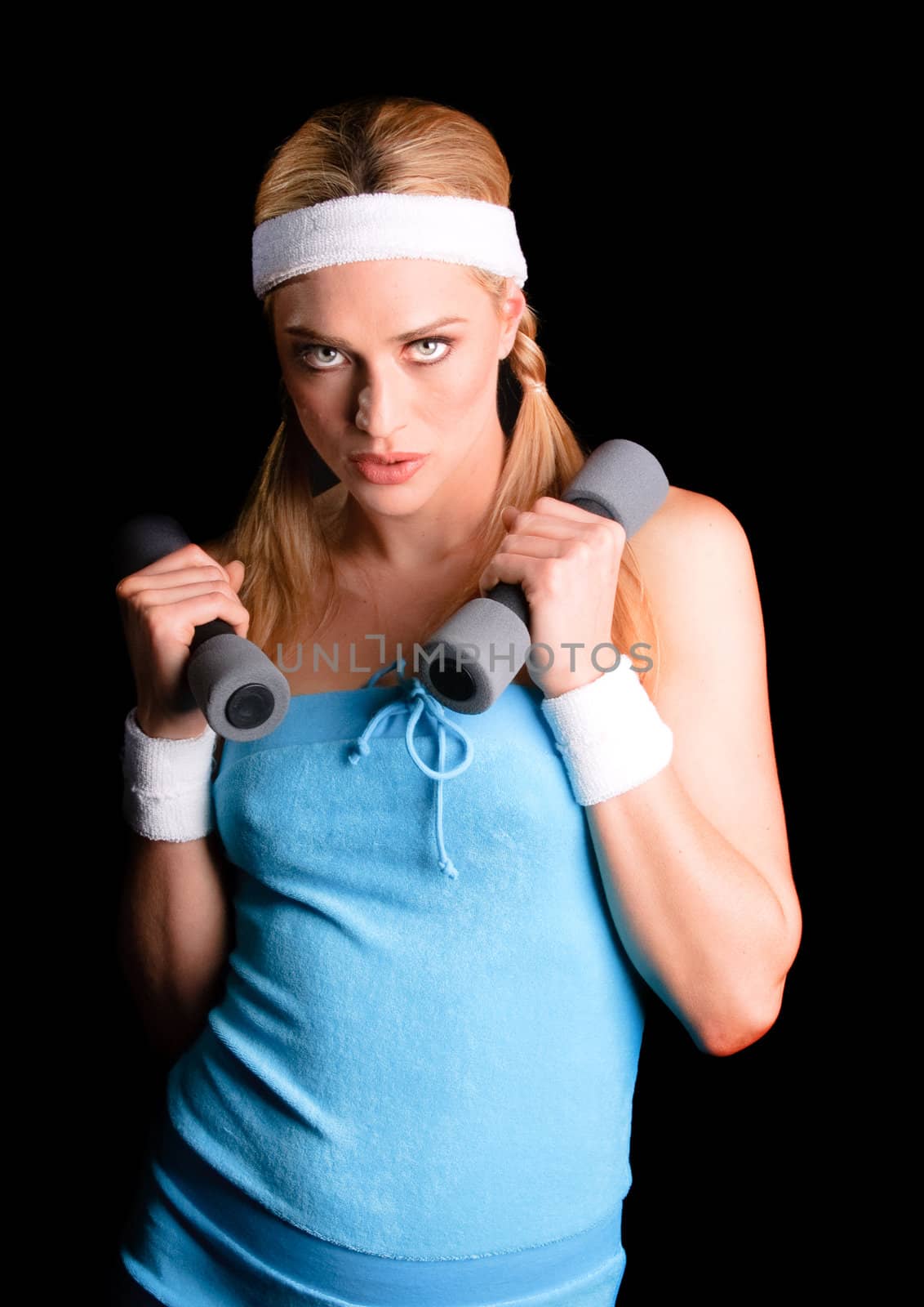 Young blond sportswoman over a black background