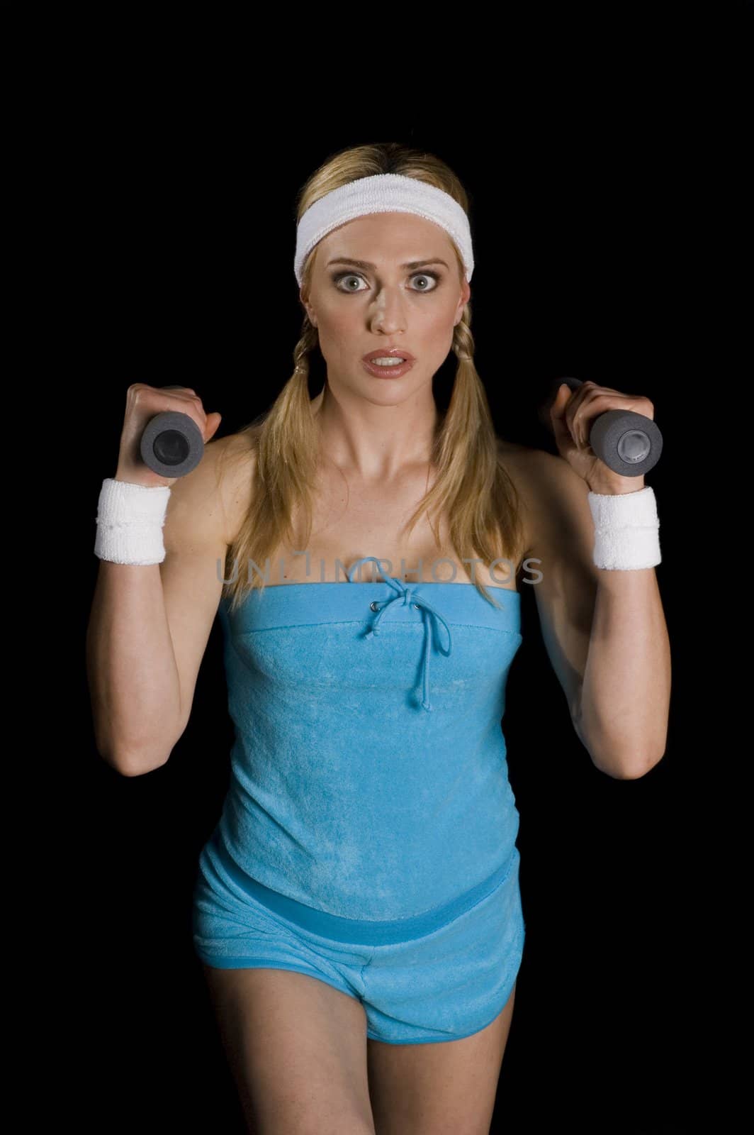 Attractive woman exercising with weights, isolated on a black background