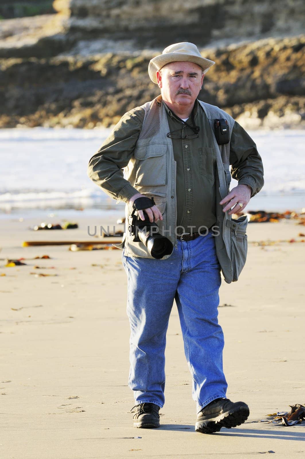 Photographer walking along the beach looking for subjects, becomes the subject of another photographer