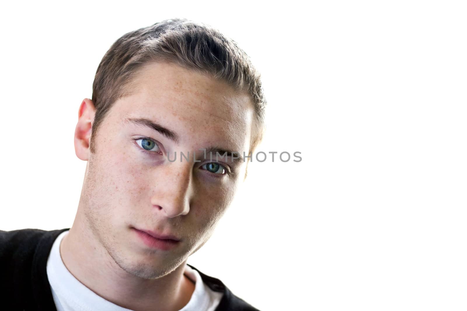 High key portrait of a serious young man in his early twenties. Shallow depth of field.