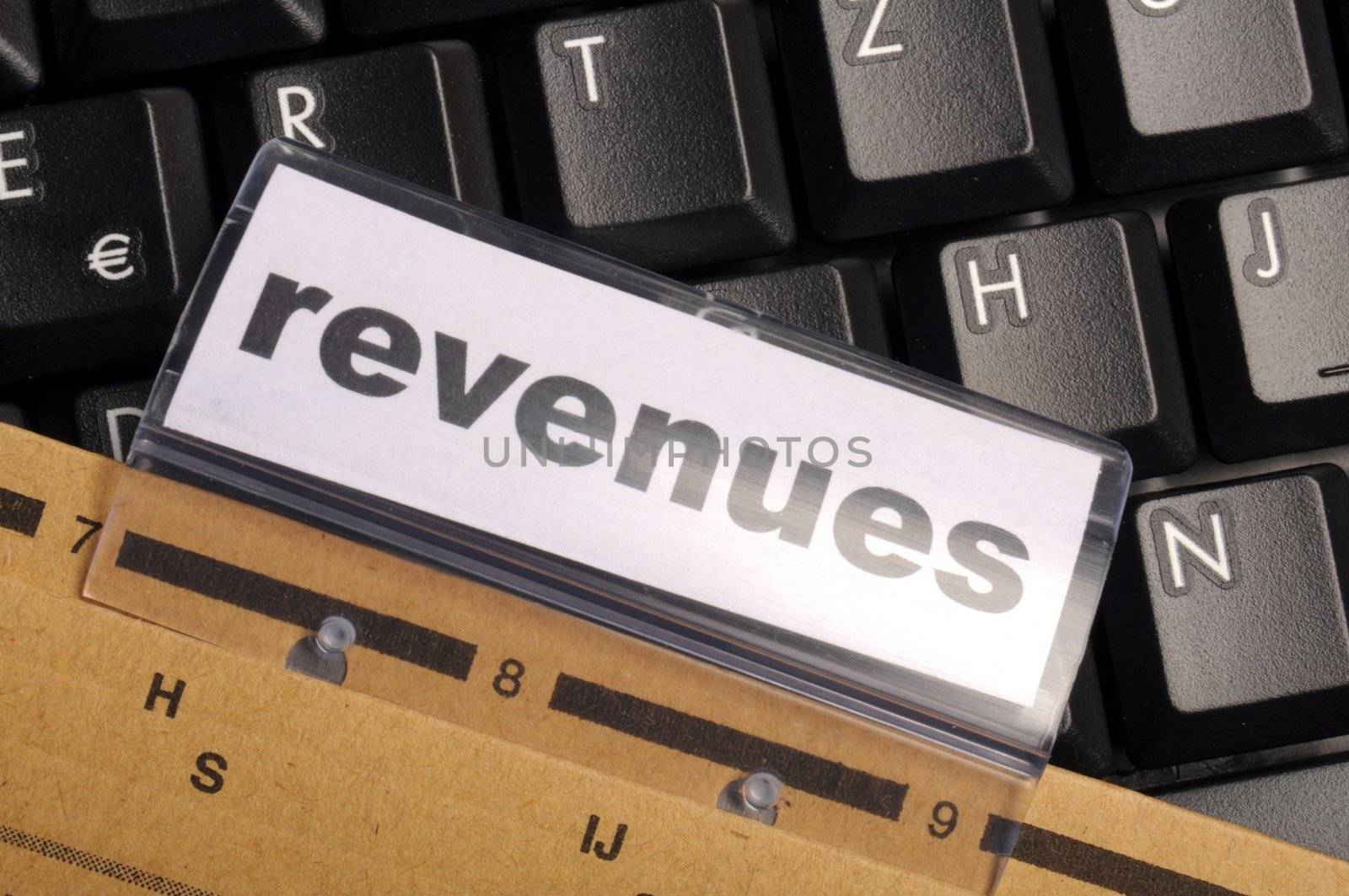 revenue or revenues word on business office folder showing financial success