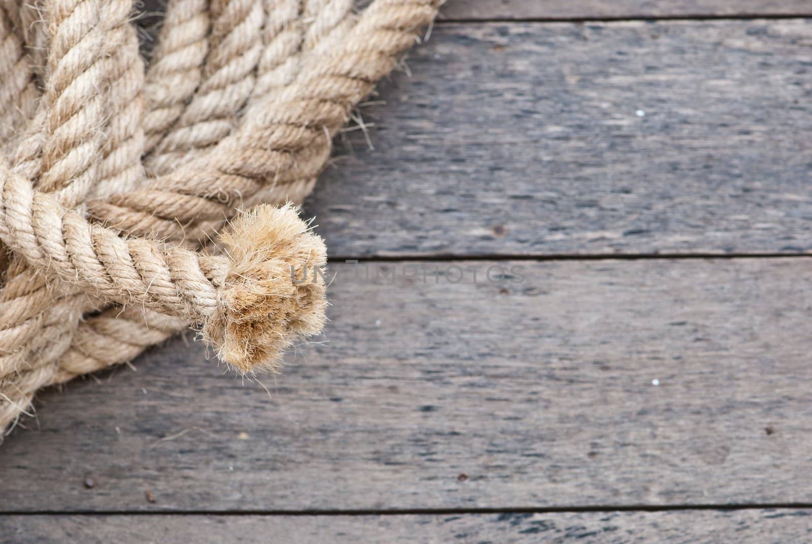 Big navy rope on wooden plank fosucing on the end of the rope, can be use as background of powerpoint
