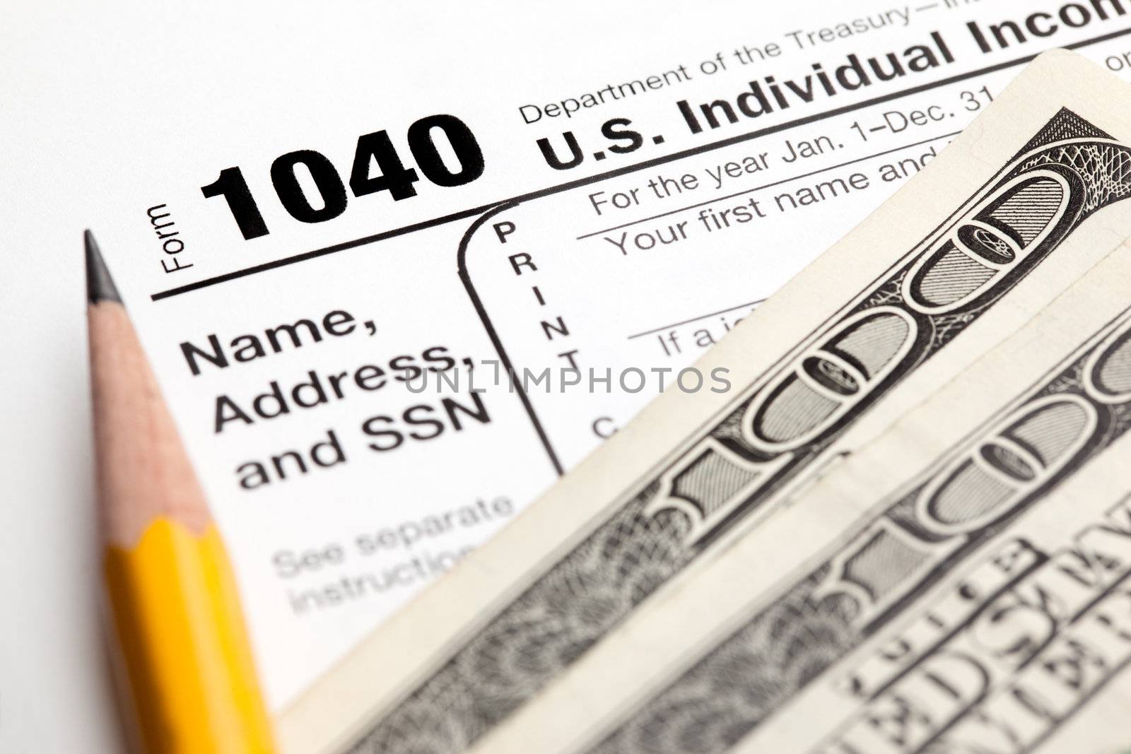 Tax time - Closeup of U.S. 1040 tax return with pencil and money