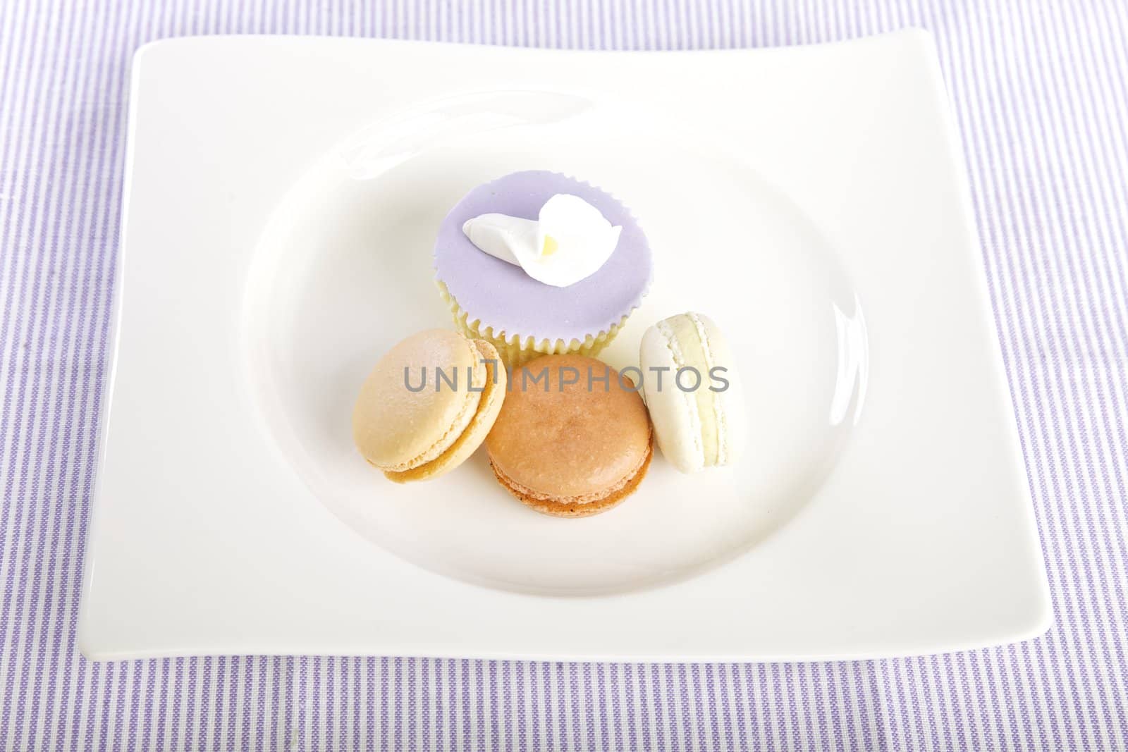 Cupcake and macaroons displayed on a plate