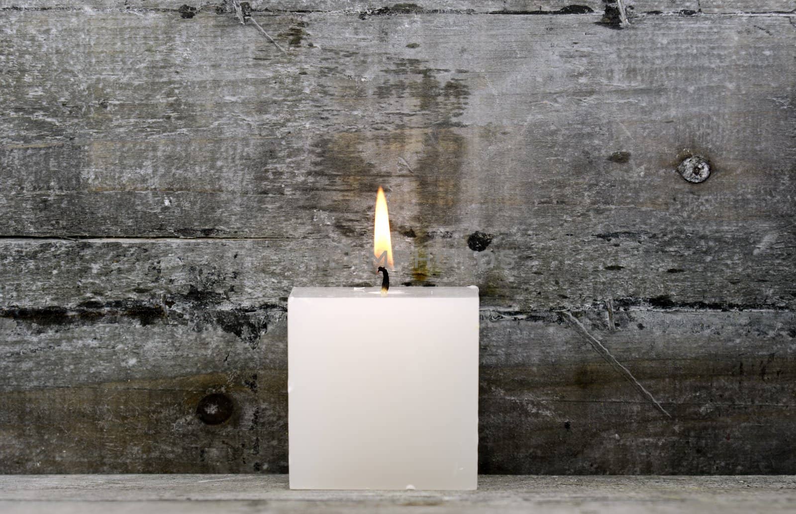 a white candle on wood background