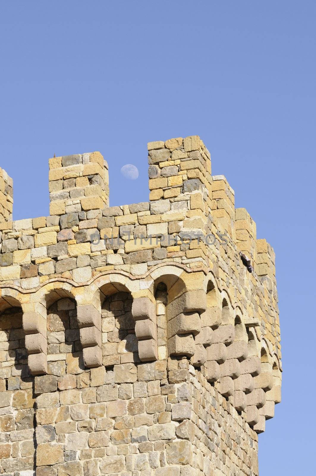 the moon rising over a Castle tower on medieval Tuscan fortification