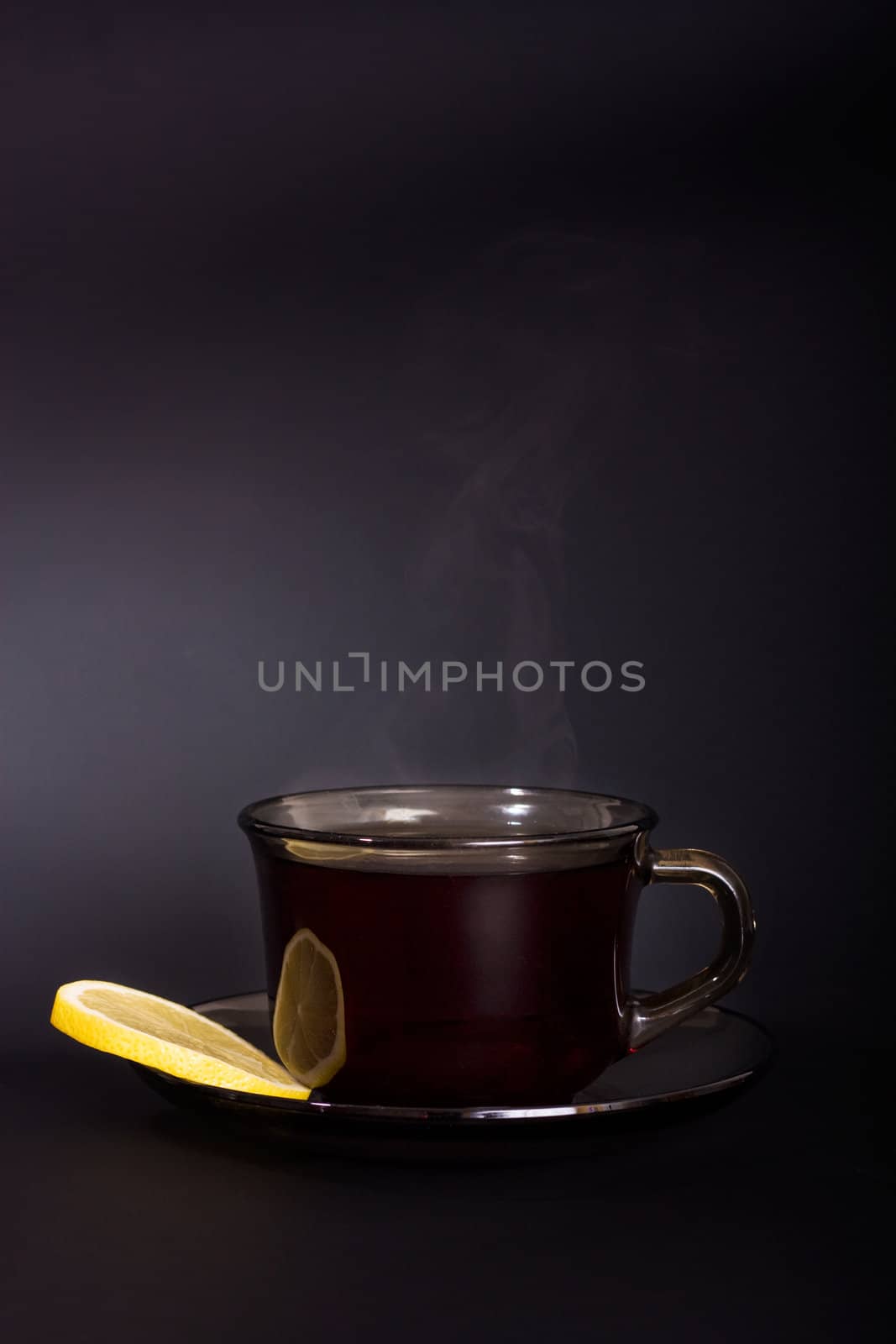 Cup of tea with lemon on a black background