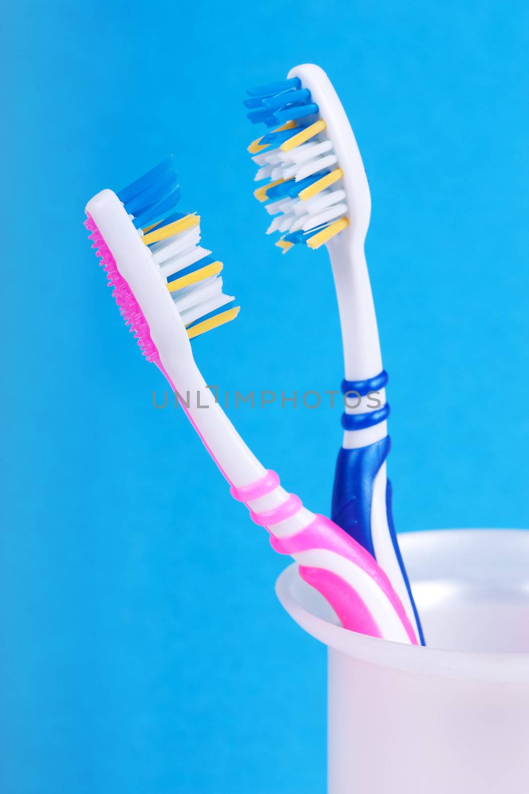 A couple of toothbrushes over blue background