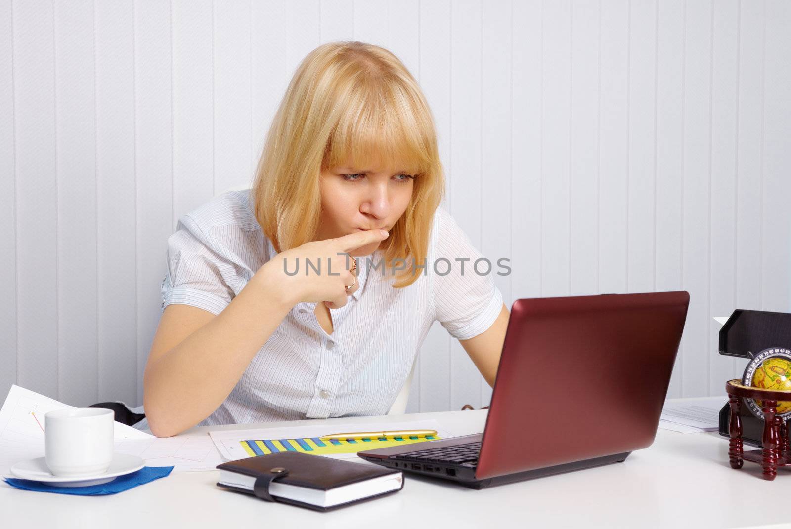 Funny young woman working in office with laptop
