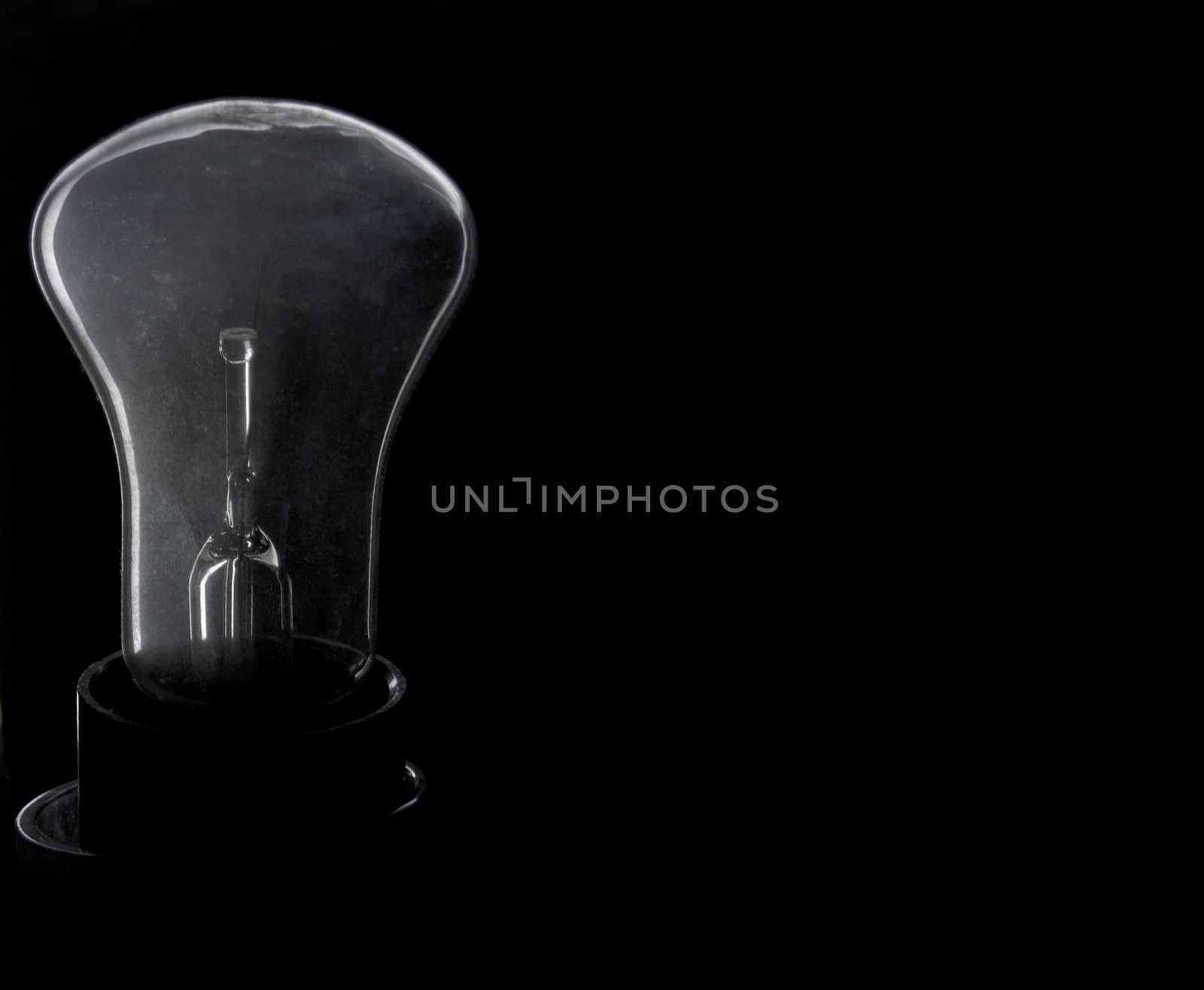 Incandescence bulb on a black background with a poorly transparent flask