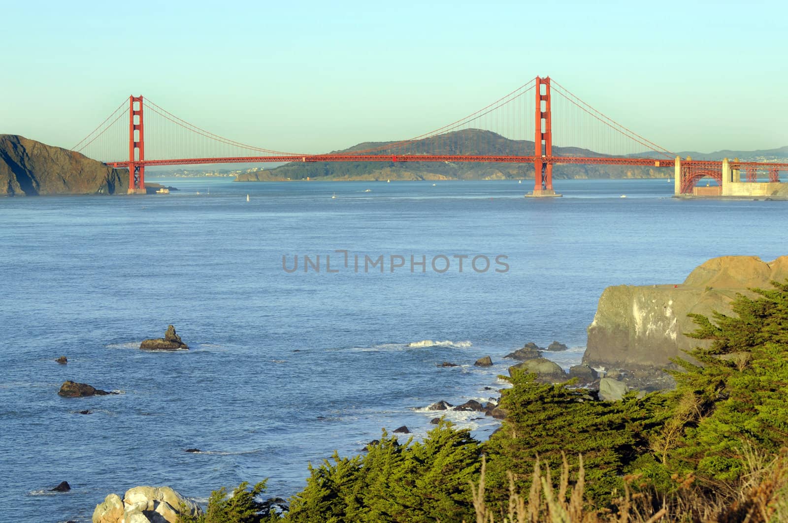 Golden gate bridge from the Presidio, sunset with sail boats in the bay