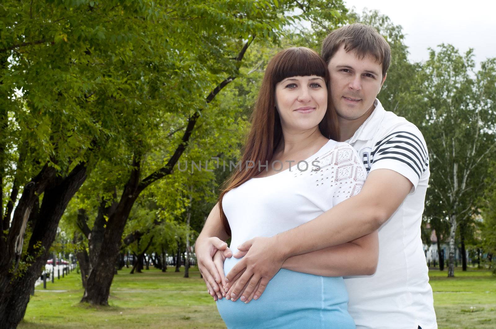 couple lays together, hugging, pregnant woman by adam121