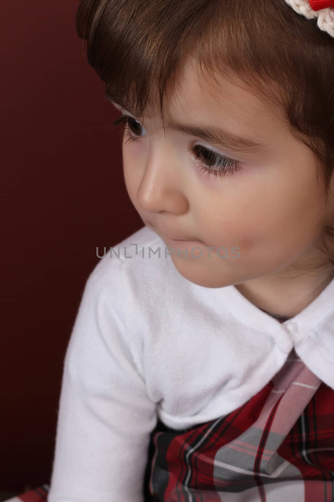 Cute little brunette toddler with serious expression