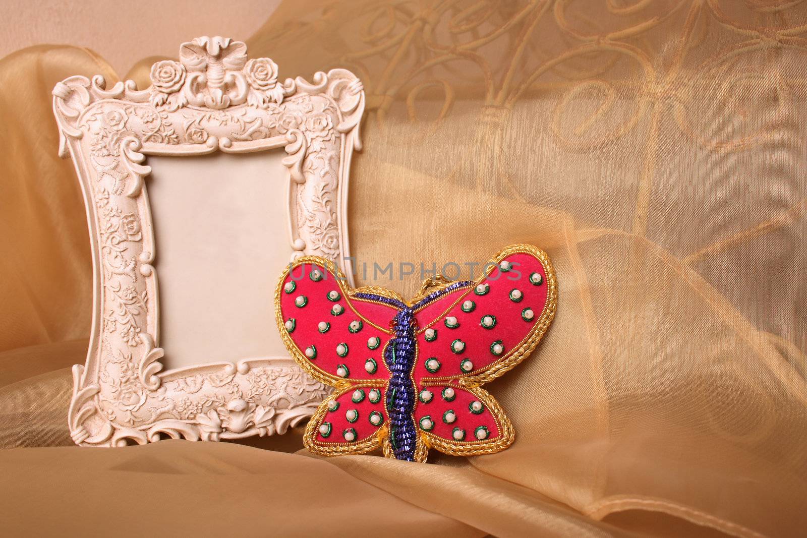 Empty Picture frame and a red beaded butterfly