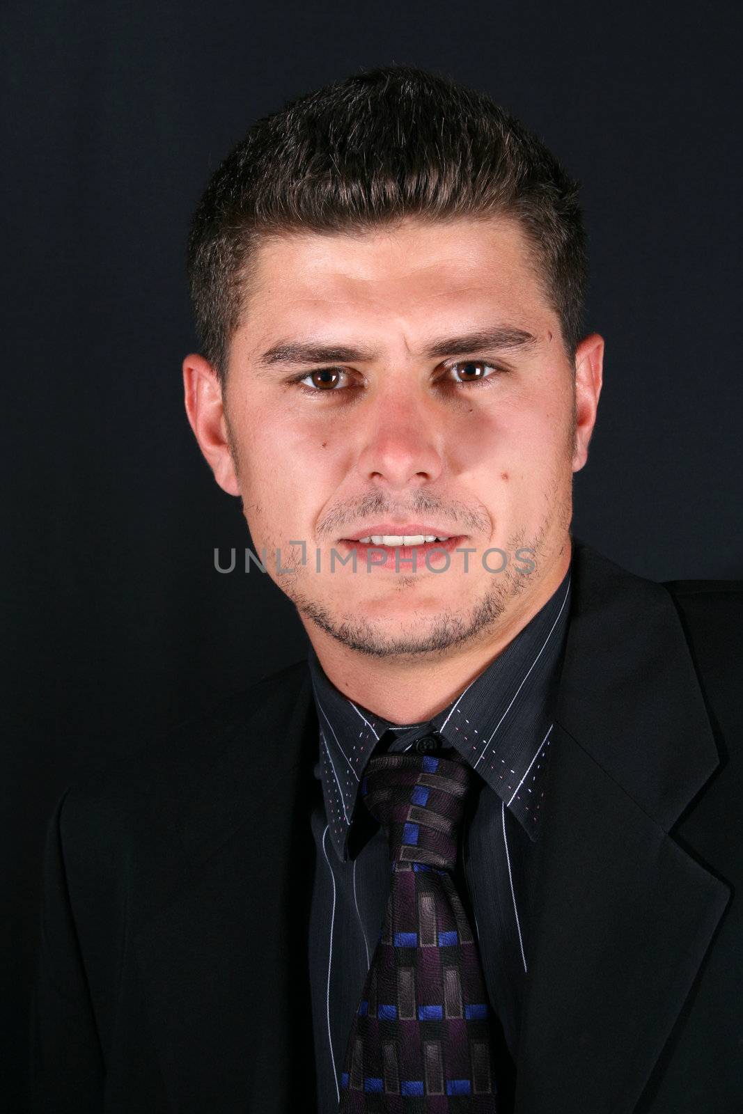 Male model in a suit and tie against a dark background