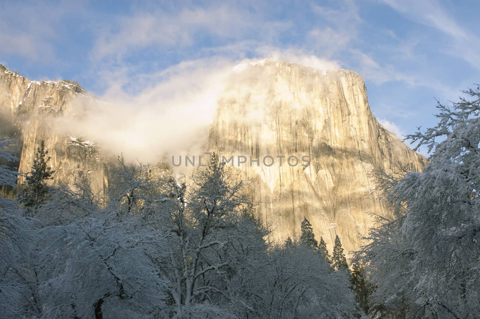 El Capitan with small whispy clouds in the winter at sunset