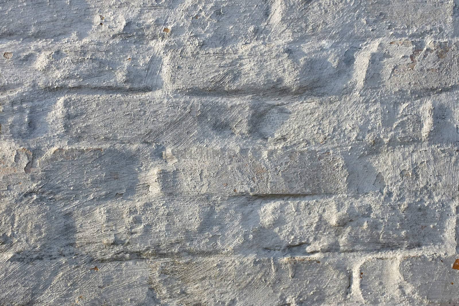 Fragment of an old brick walls painted with lime