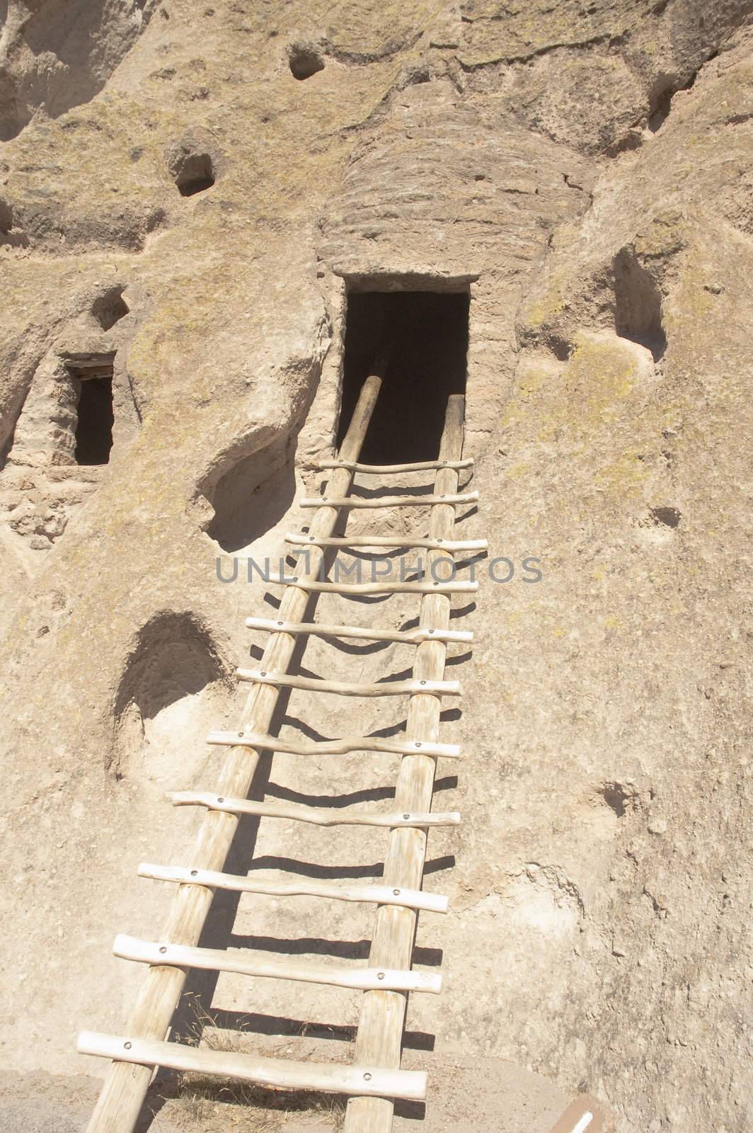 Ancient Anasazs or Puebloan indian dwelling at Bandelier in New Mexico, with ladder going up to the entrance of the Kiva