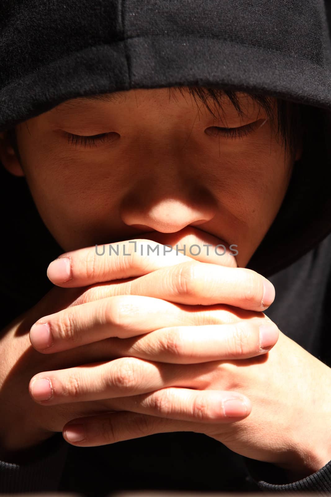 Closeup portrait of a young man praying to god by cozyta