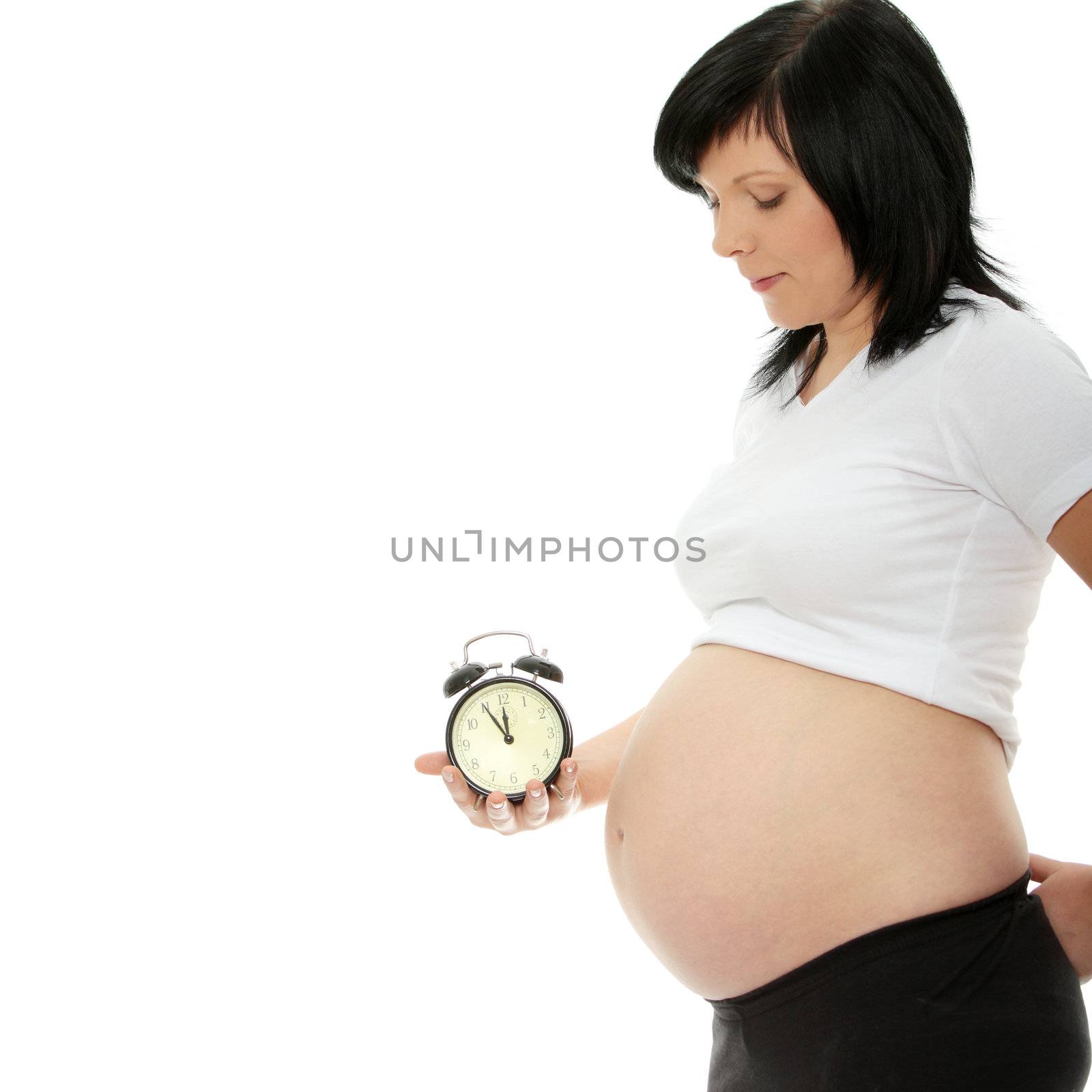 Pregnant woman holding alarm clock isolated in white