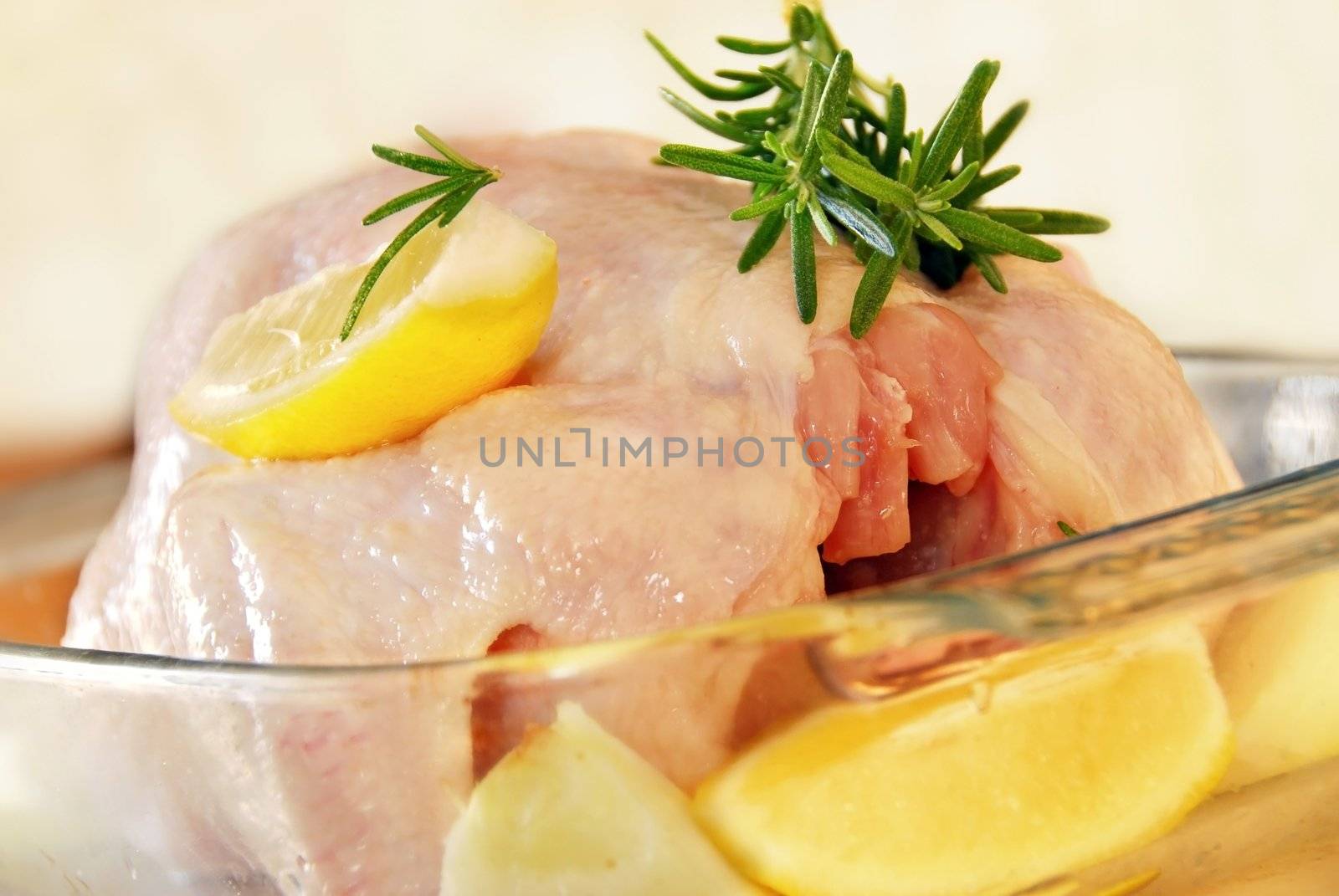 raw chicken meat with rosemary and lemon ready to bake