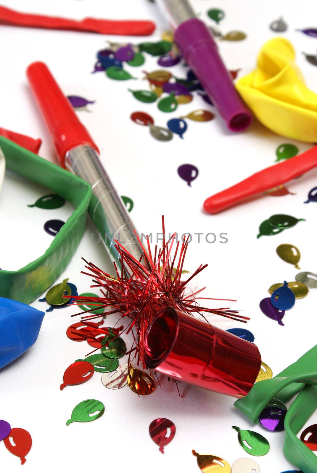 A red noise maker with confetti on a white background.