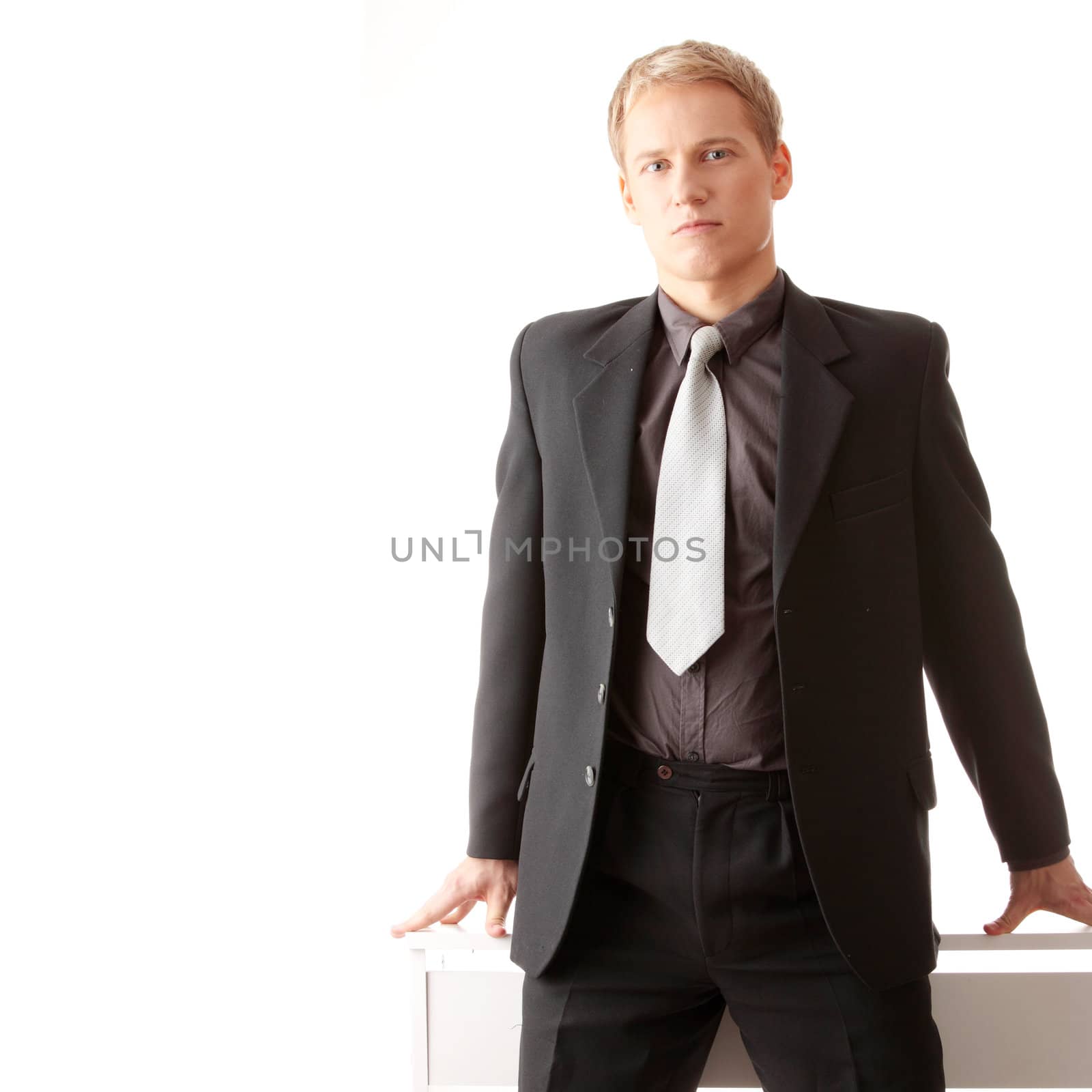 Young businessman siting on desk isolated