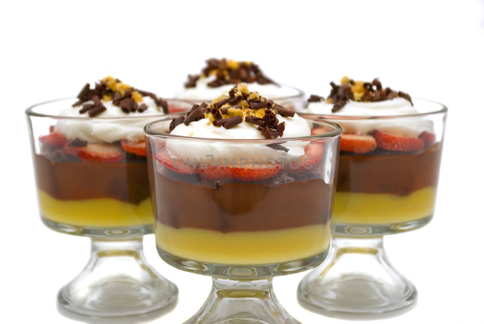 Trifle with chocolate puding, vanilla pudding, strawberries, chocolate cake pieces, whip cream, walnuts and chocolate curls