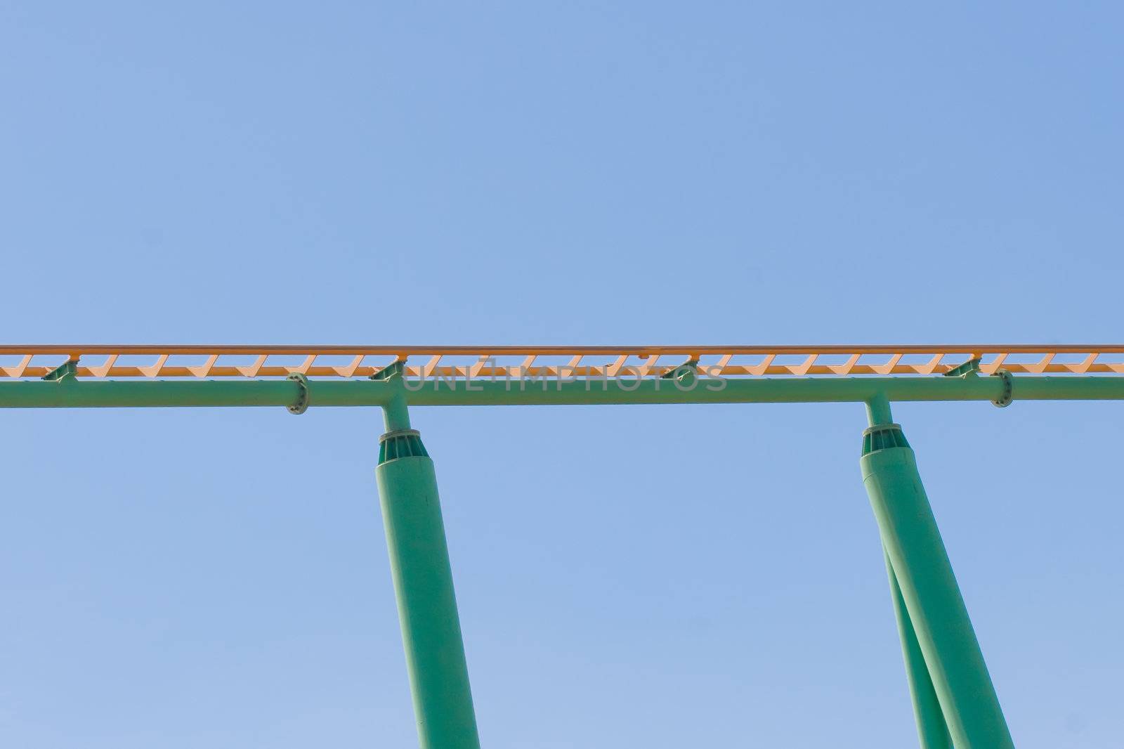 Rollercoaster track against a brilliant blue sky