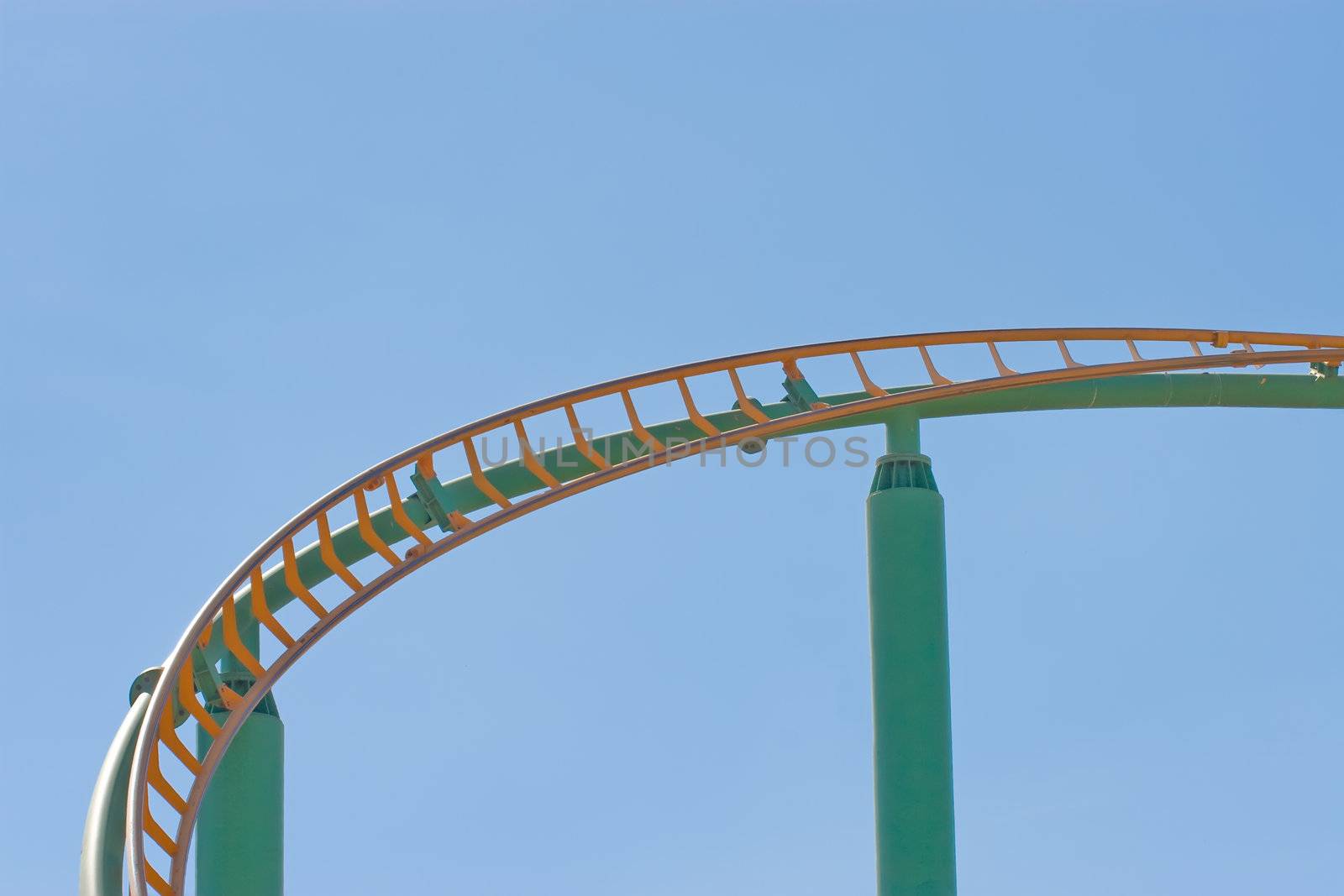 Rollercoaster track against a brilliant blue sky