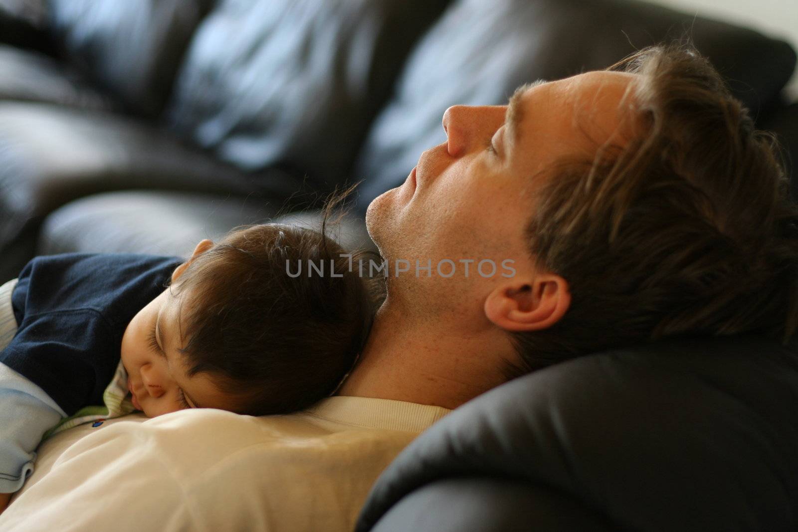 Baby asleep on his father's chest.;
