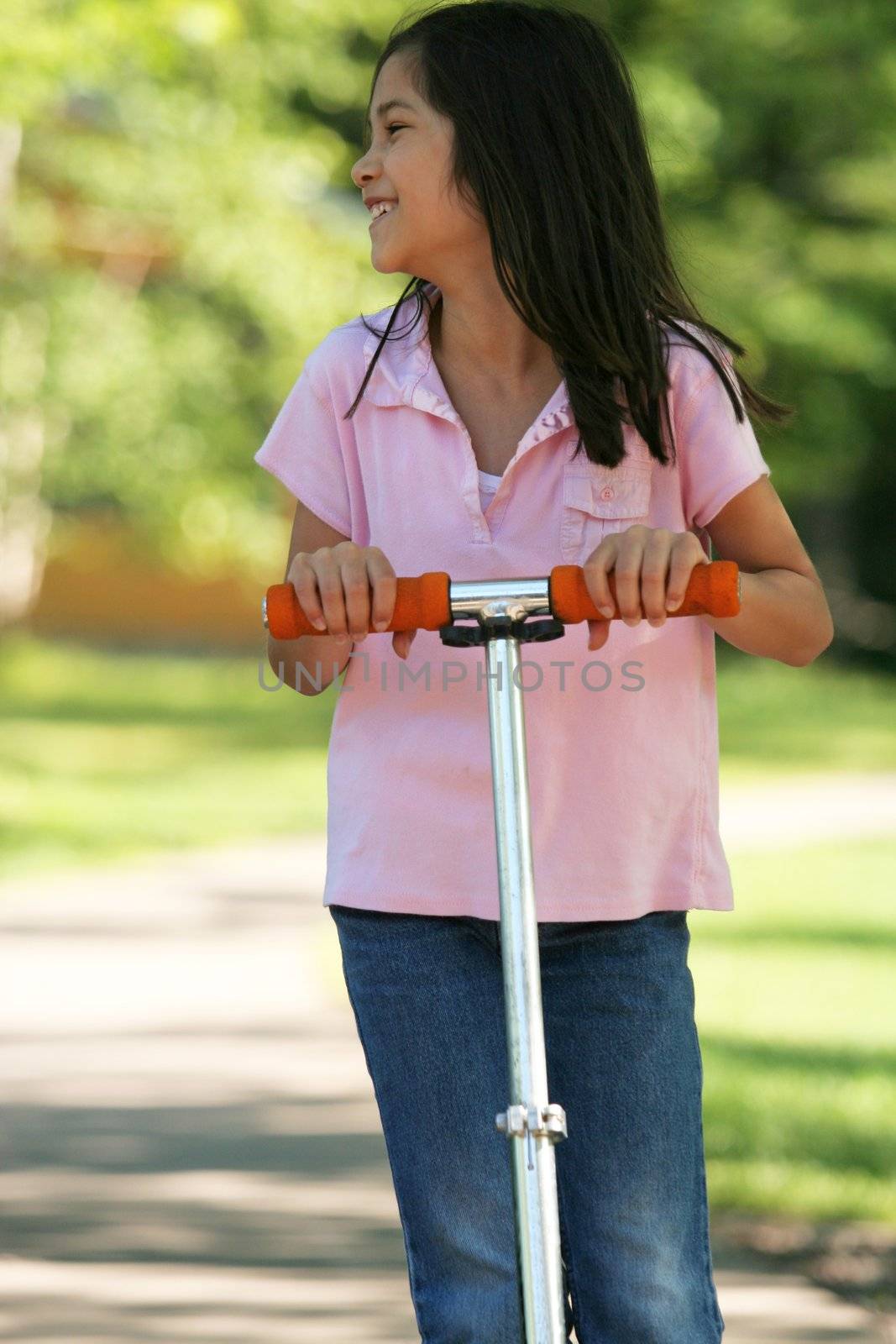 Girl riding a scooter on sidewalk by jarenwicklund