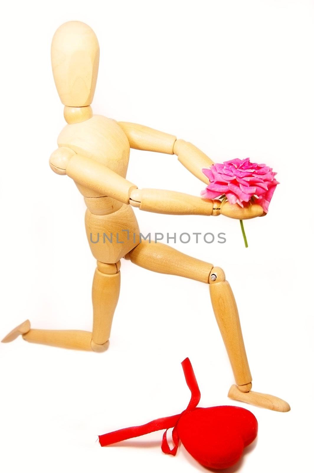 Wooden figurine man holding rose, standing on knees